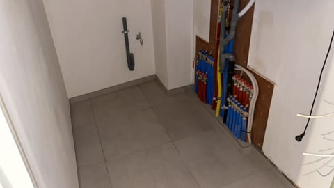 Empty hallway with gray tile floor and white walls